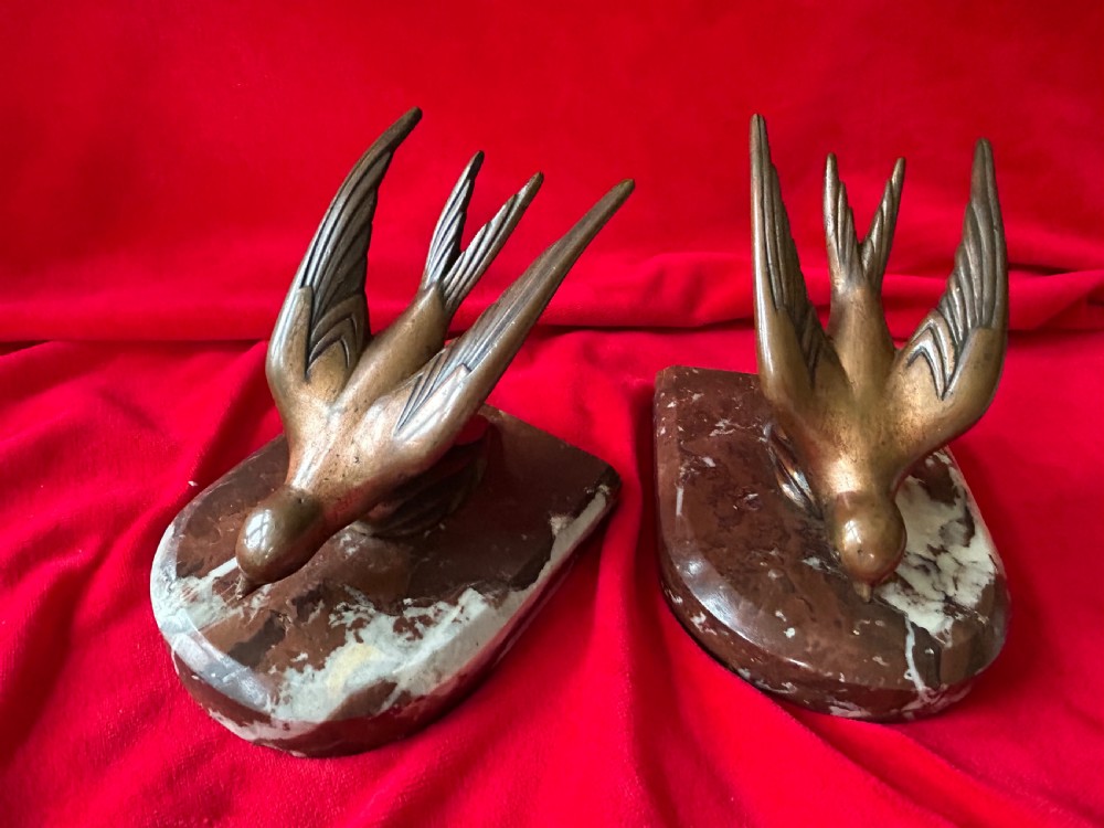 A pair of French Art Deco bronze swallow bookends mounted on polished reddish-brown veined marble bases. View III