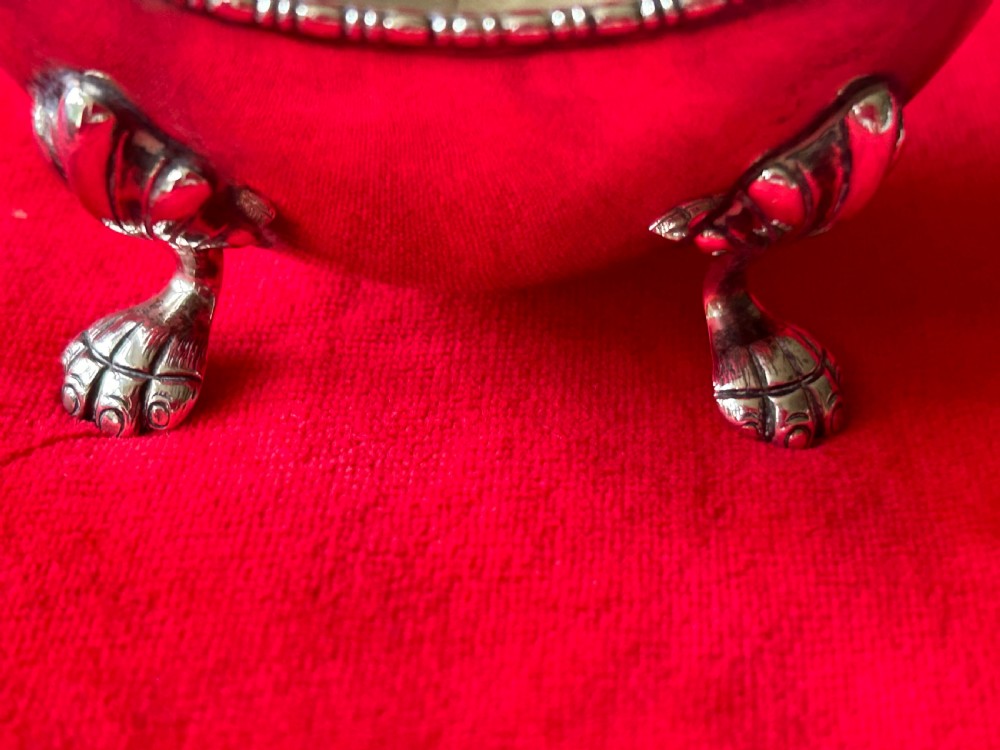 A polished silver bonbon dish with a high overhead handle, beaded rim, and claw feet. View III