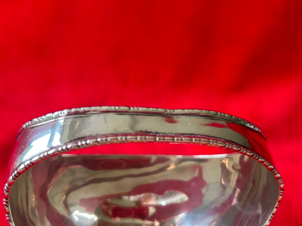 A polished silver bonbon dish with a high overhead handle, beaded rim, and claw feet. View IV