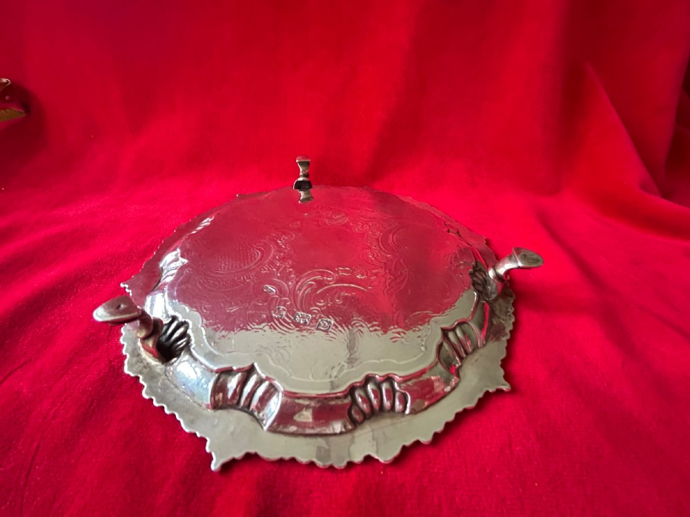 A circular George III sterling silver card tray featuring a shell and scroll cast rim with intricate hand-engraved foliate ornamentation on the flat surface. View VI