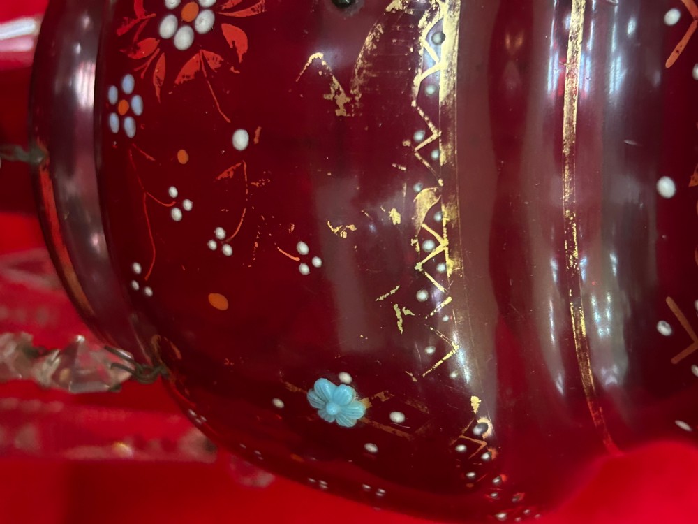 A pair of Victorian ruby glass mantel lustres featuring scalloped edges, hand-painted floral enamel, gilding, and suspended cut crystal prisms. View VIII