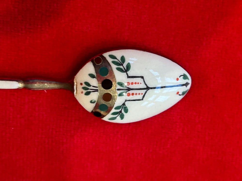 A cased set of six George V sterling silver coffee spoons with white, green, and red enamel decoration in a velvet-lined fitted box. View II
