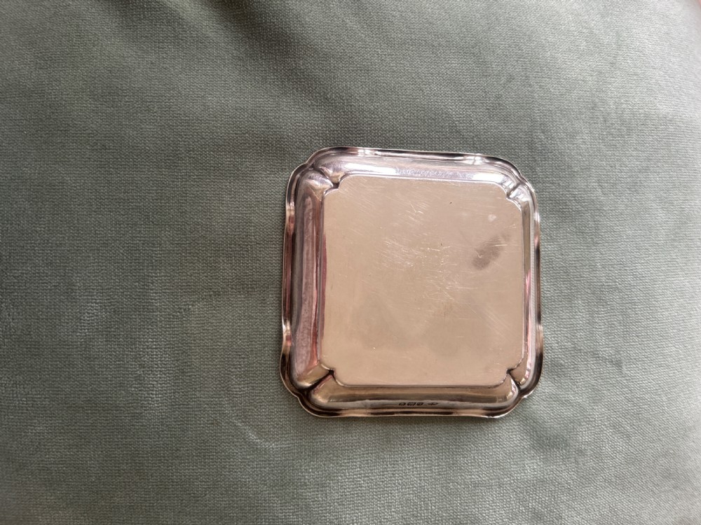 A small square silver dish featuring scalloped edges and engraved lettering dated 1948 in the centre. View II