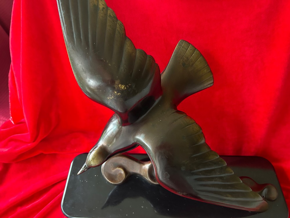 A French Art Deco dark bronze sculpture depicting a stylized bird with outstretched wings in flight mounted on a black rectangular marble base. View II