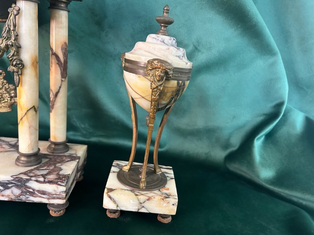 A French late 19th-century clock garniture in veined cream marble and gilt metal featuring a columned clock flanked by two matching cassolette urns. View III