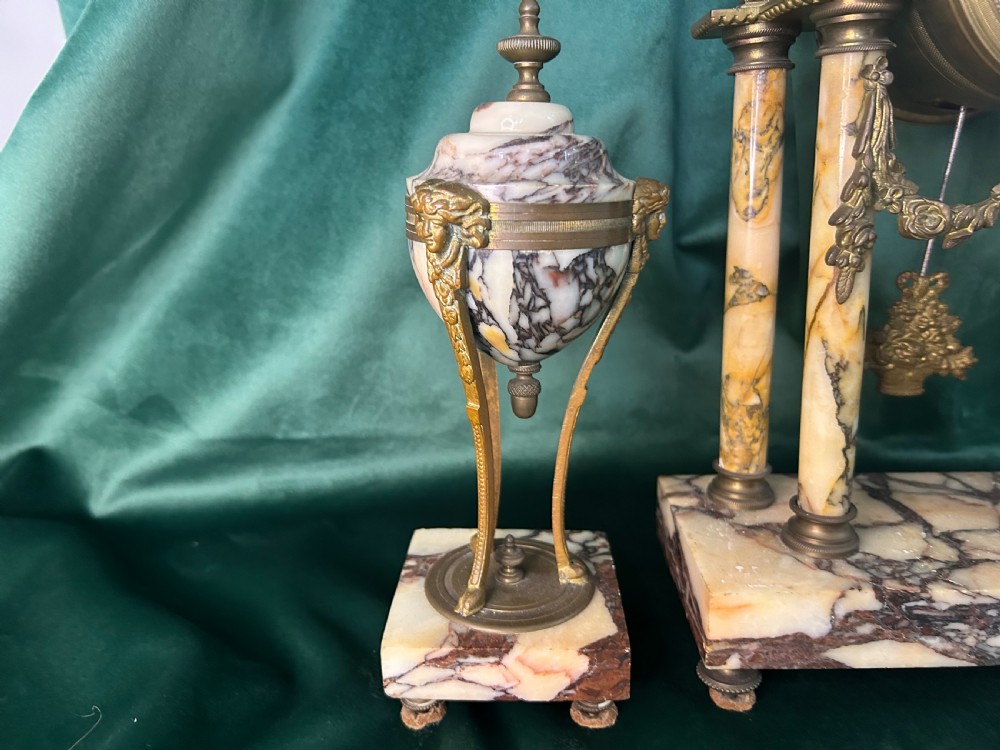 A French late 19th-century clock garniture in veined cream marble and gilt metal featuring a columned clock flanked by two matching cassolette urns. View V