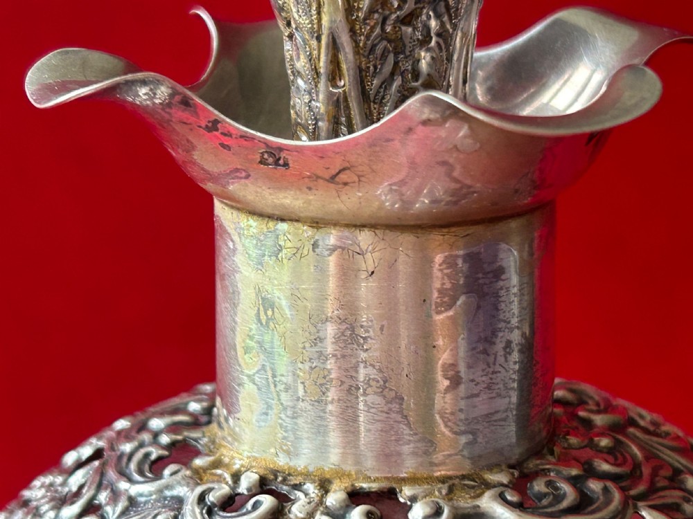 An Edwardian clear glass decanter featuring a pinched waist, decorative pierced silver overlay around the shoulder, and an ornate silver stopper. View III