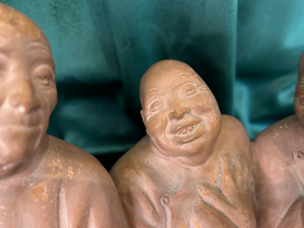 An Art Deco terracotta sculpture depicting three expressive figures mounted on a black marble base. View III