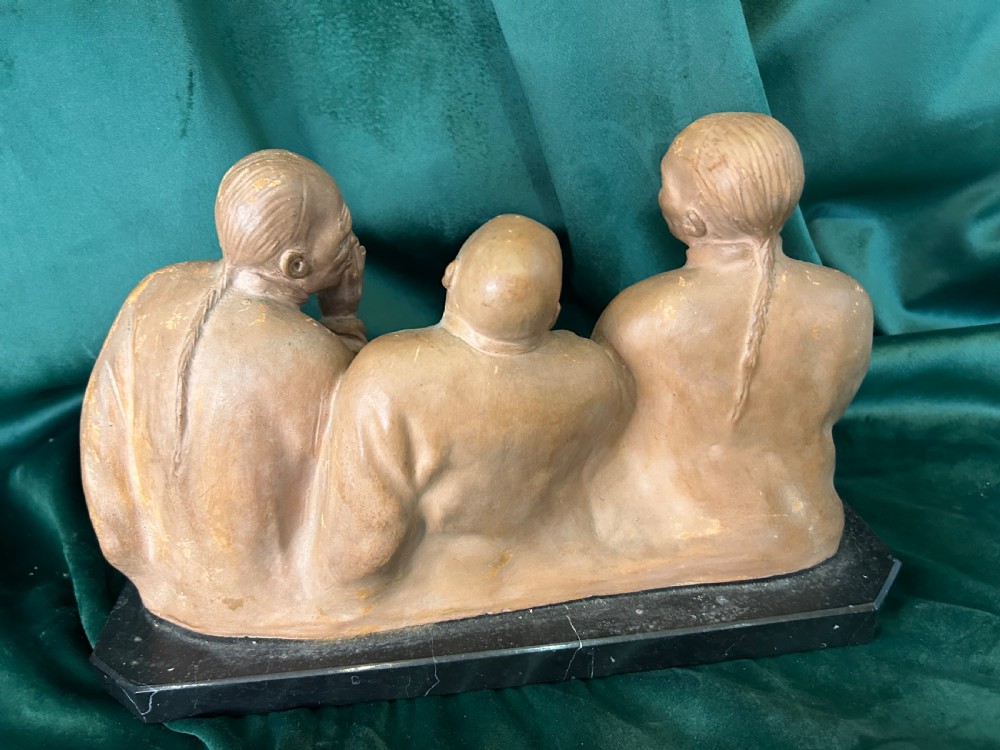 An Art Deco terracotta sculpture depicting three expressive figures mounted on a black marble base. View VI