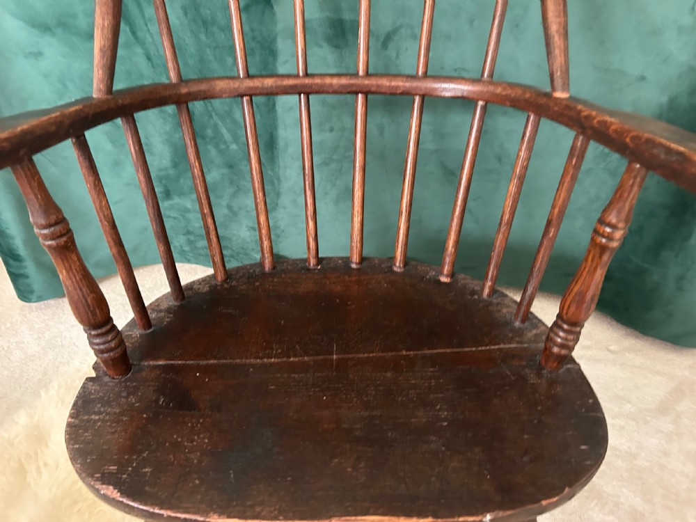 A dark stained wooden Windsor rocking chair featuring a spindle hoop back, curved armrests, turned legs, and wooden runners. View II