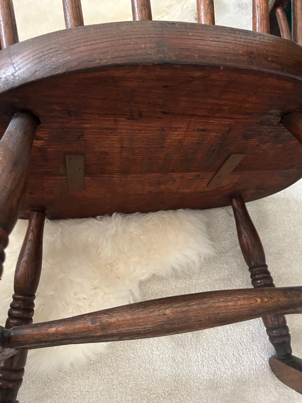 A dark stained wooden Windsor rocking chair featuring a spindle hoop back, curved armrests, turned legs, and wooden runners. View IV