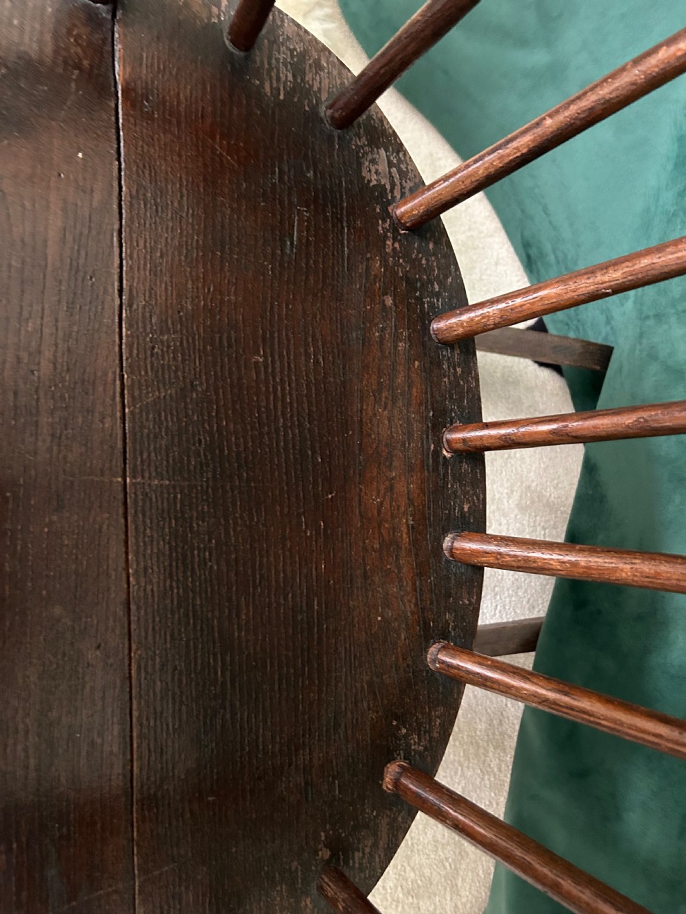 A dark stained wooden Windsor rocking chair featuring a spindle hoop back, curved armrests, turned legs, and wooden runners. View V