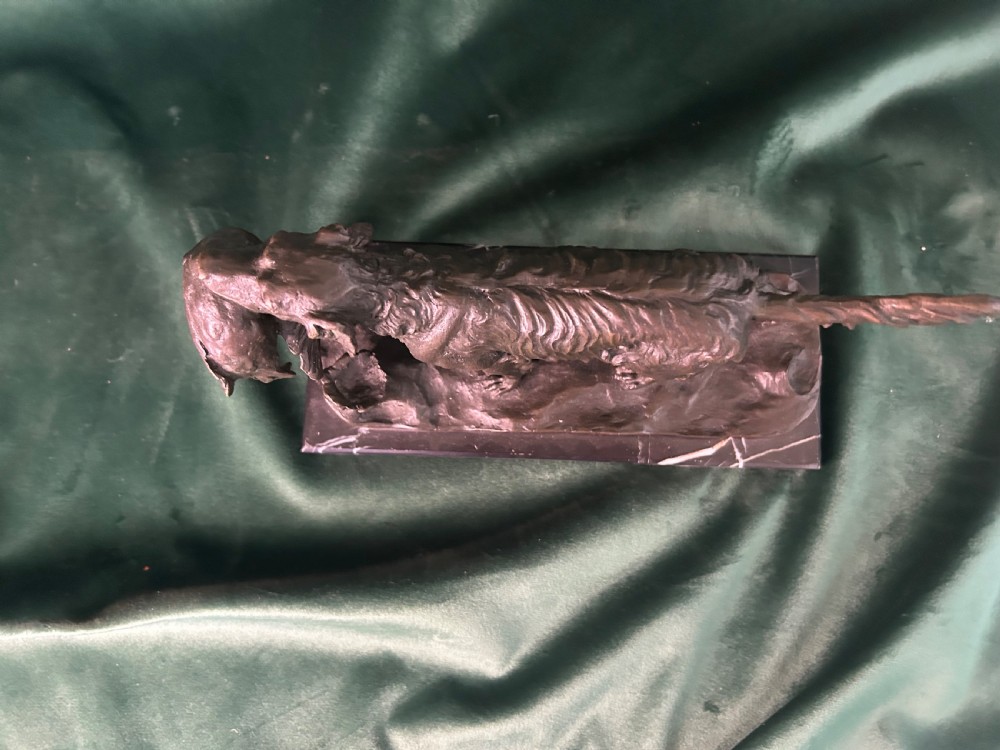 A cast bronze figure of a hunting dog holding a game bird in its jaws, set on a naturalistic ground base and mounted on a black veined marble plinth. View II