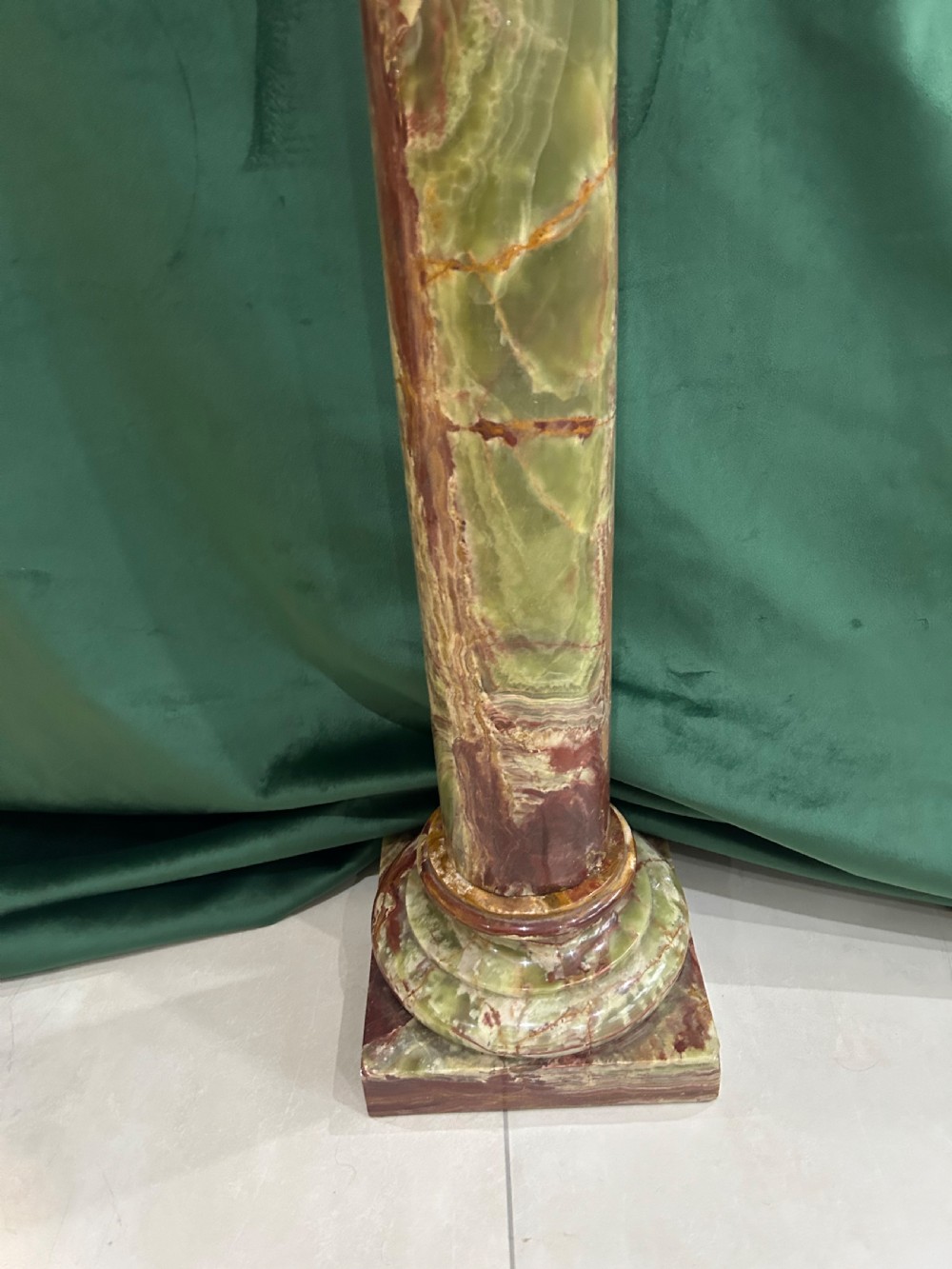 A tall variegated green onyx column pedestal featuring a square moulded top capital and a stepped square base. View II