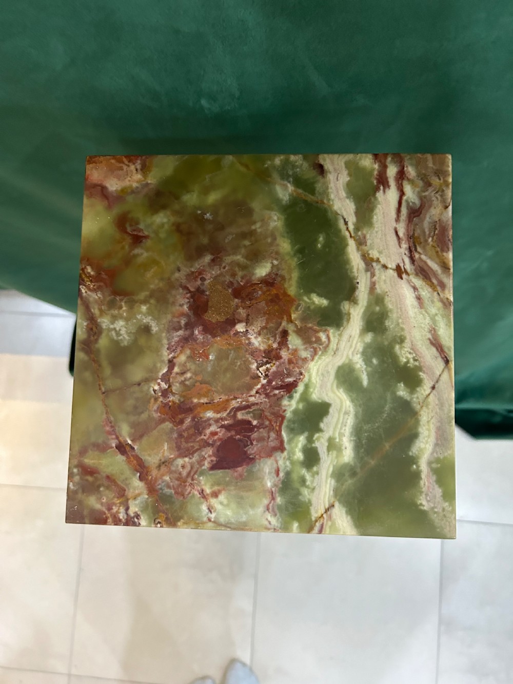 A tall variegated green onyx column pedestal featuring a square moulded top capital and a stepped square base. View IV