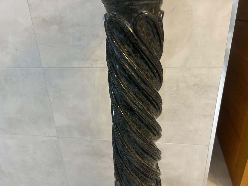 A tall dark green marble pedestal featuring a spiralled shaft, a circular top capital, and an octagonal base. View IV