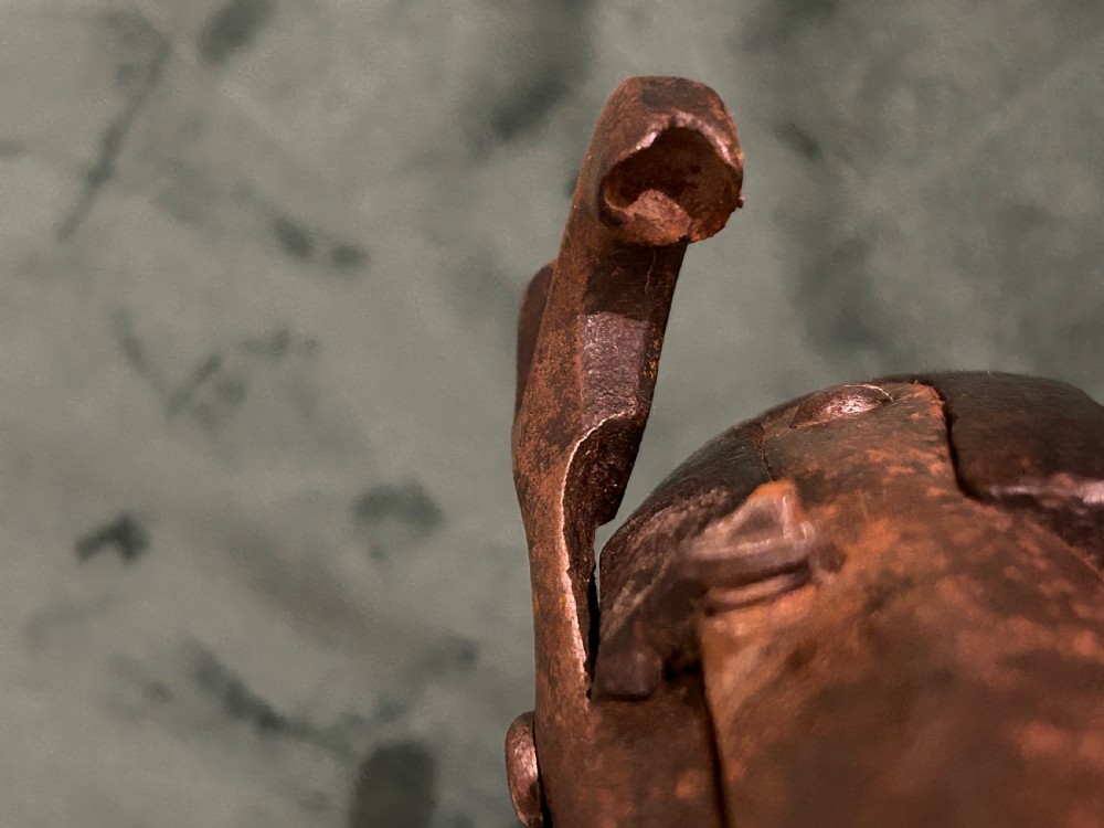 An antique single-barrel percussion pistol featuring a carved walnut stock, a metal hammer mechanism, and brass fittings along the trigger guard and butt cap. View IV