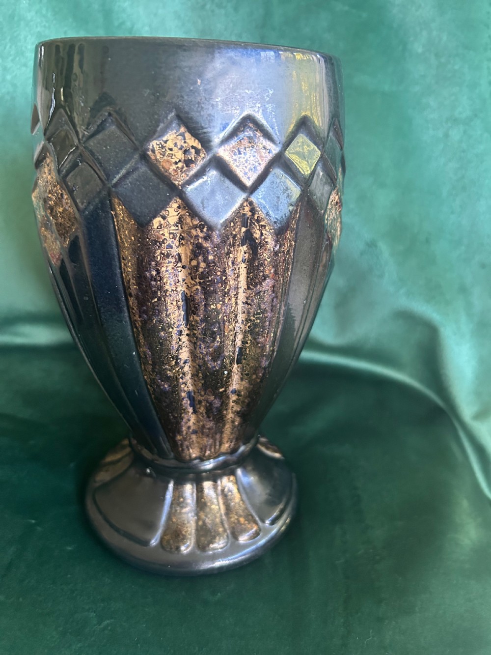 An Art Deco ceramic vase featuring a dark glaze with geometric diamond relief patterns highlighted in gold detailing. View II