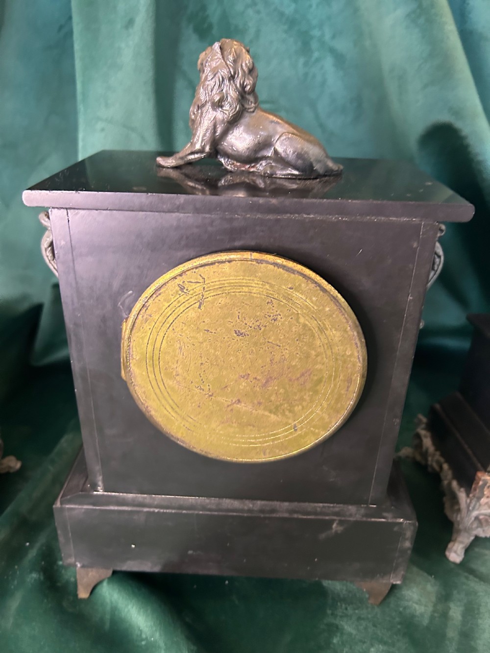 A three-piece French black slate clock garniture set comprising a central mantel clock topped with a lion figure and flanked by two matching multi-branch candelabra. View XI