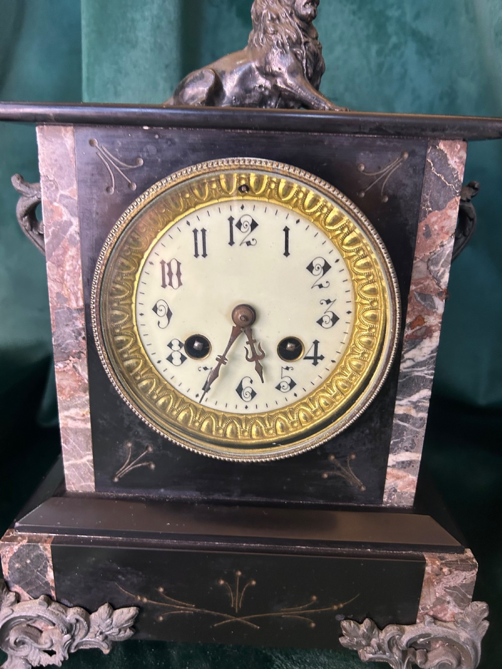 A three-piece French black slate clock garniture set comprising a central mantel clock topped with a lion figure and flanked by two matching multi-branch candelabra. View XIII