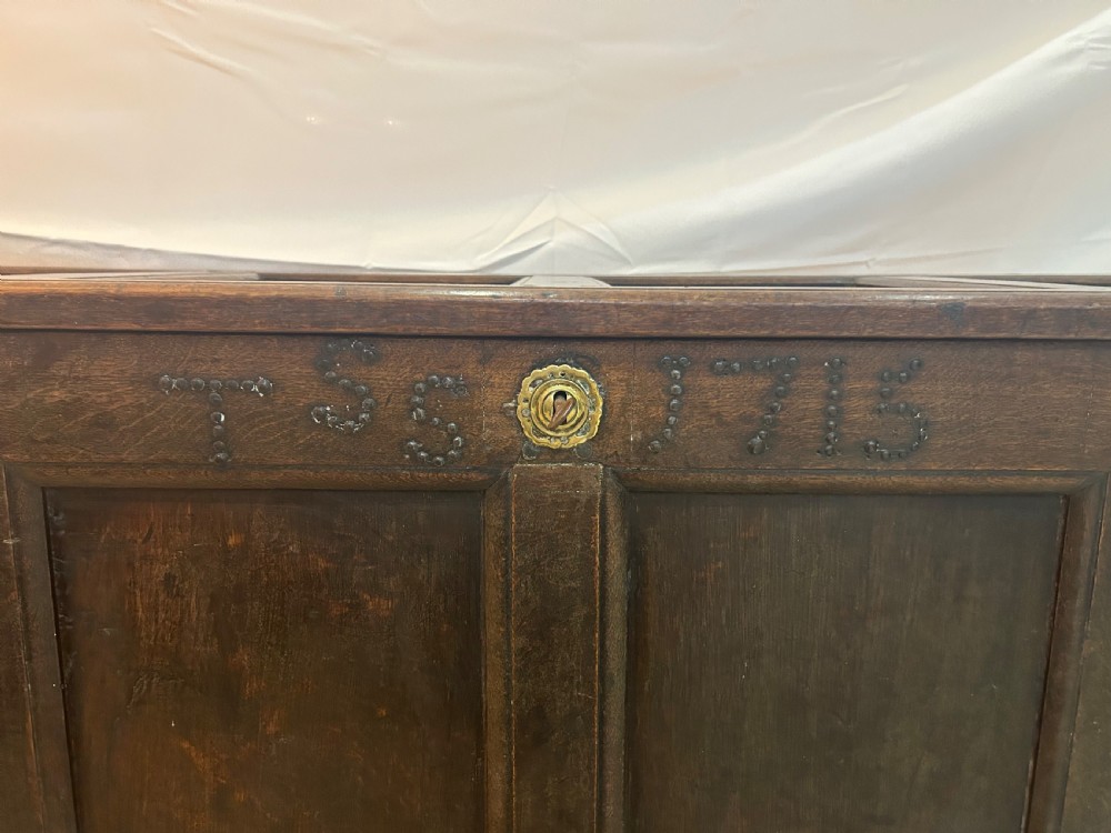 An 18th-century dark oak mule chest featuring a four-panel front, two base drawers with brass handles, and a hinged lid. View IV