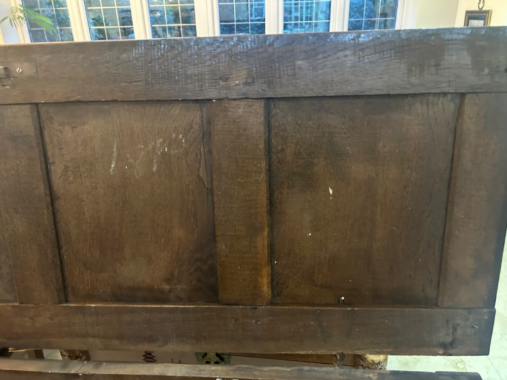 An 18th-century dark oak mule chest featuring a four-panel front, two base drawers with brass handles, and a hinged lid. View XIII