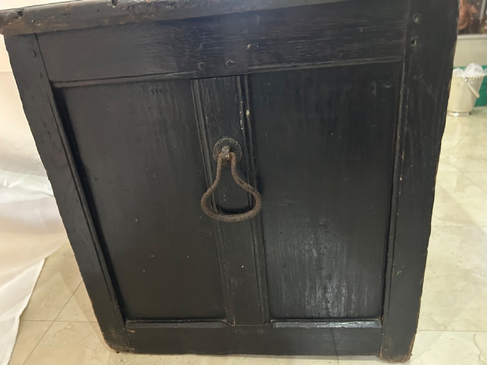 A dark carved wooden antique coffer featuring four rectangular front panels decorated with geometric lozenge and rosette motifs. View VI