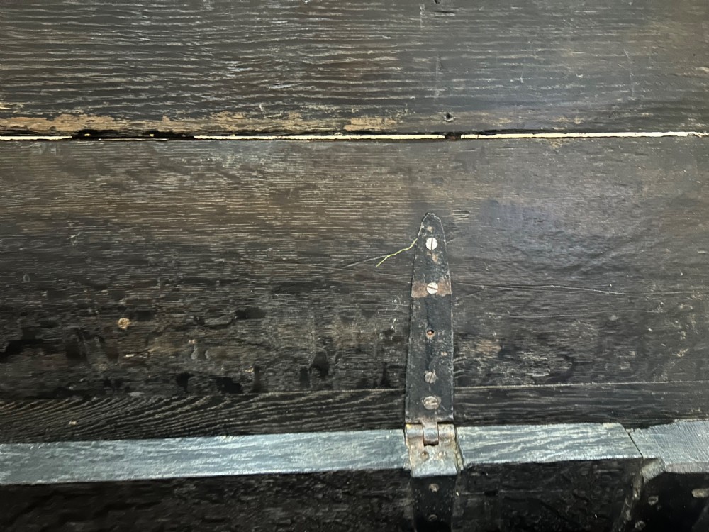 A dark carved wooden antique coffer featuring four rectangular front panels decorated with geometric lozenge and rosette motifs. View XII