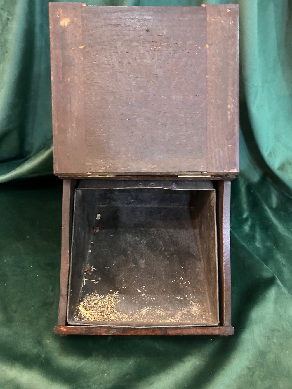 An antique dark oak wooden coal box with sloped lid, carved leaf panel, brass carrying handle, and ornate brass hinges. View III