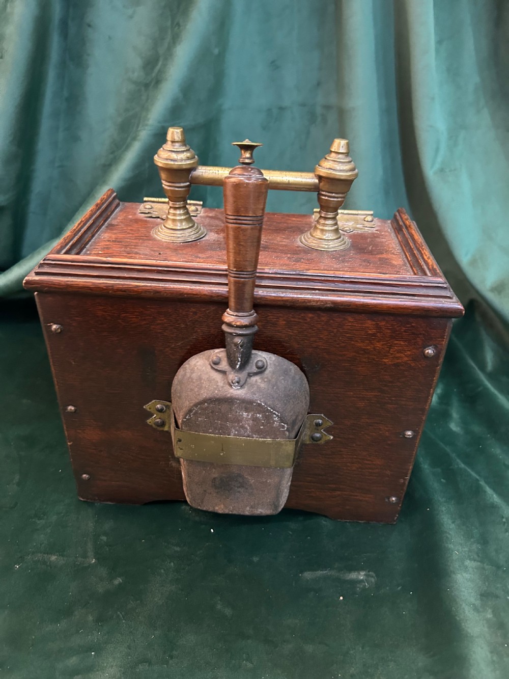 An antique dark oak wooden coal box with sloped lid, carved leaf panel, brass carrying handle, and ornate brass hinges. View IV