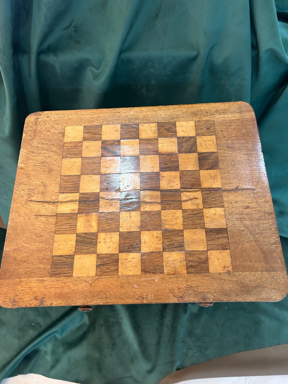 A Victorian warm brown wood games work table featuring an inlaid chessboard top, a single drawer, a damask fabric sewing well, and a turned pedestal base. View II
