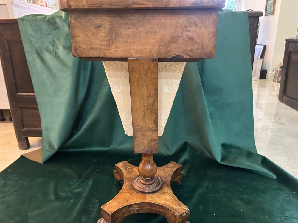 A Victorian warm brown wood games work table featuring an inlaid chessboard top, a single drawer, a damask fabric sewing well, and a turned pedestal base. View VI
