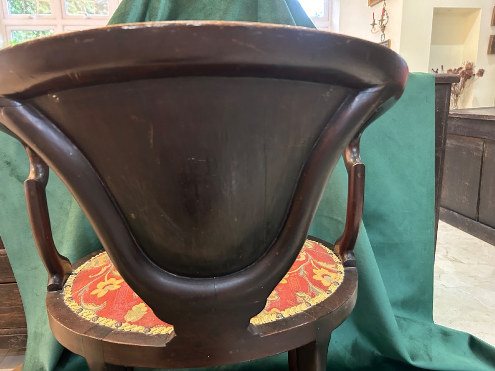 A nineteenth-century dark mahogany tub chair featuring intricate floral marquetry on the back splat and cabriole legs, fitted with a red floral upholstered seat. View V