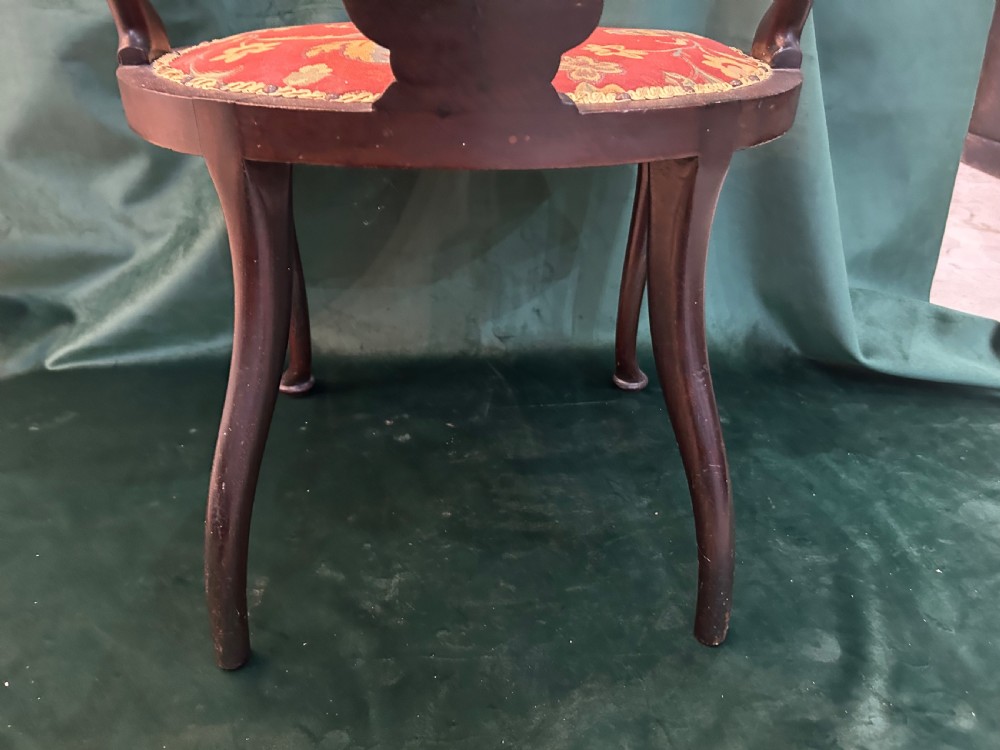 A nineteenth-century dark mahogany tub chair featuring intricate floral marquetry on the back splat and cabriole legs, fitted with a red floral upholstered seat. View VII