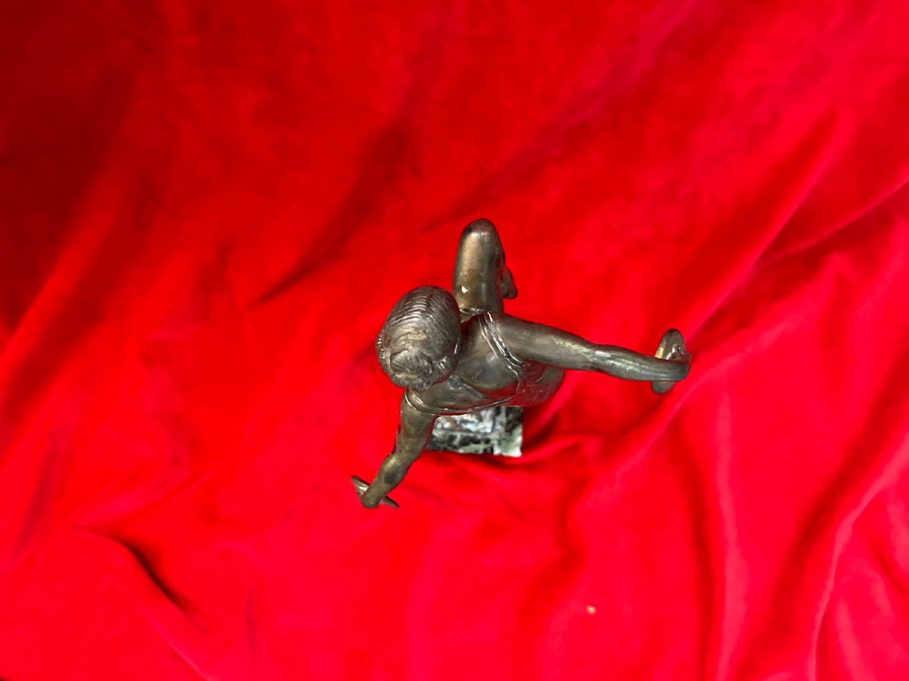 An Art Deco silver-plated figure of a female dancer balanced on one foot atop a square dark marble base. View III