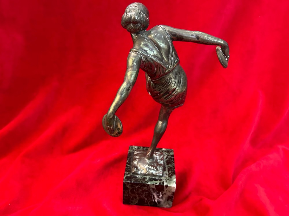 An Art Deco silver-plated figure of a female dancer balanced on one foot atop a square dark marble base. View IV