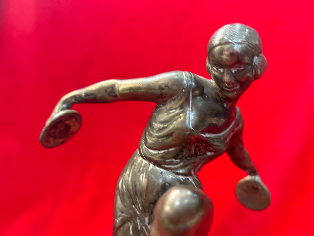 An Art Deco silver-plated figure of a female dancer balanced on one foot atop a square dark marble base. View V