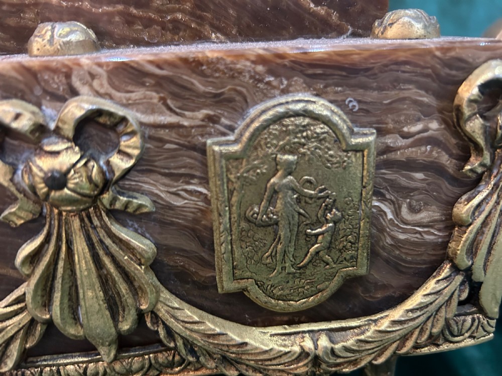 An antique three-piece French ormolu clock garniture featuring a central mantel clock decorated with a classical female figurine and marble base, flanked by two matching five-arm candelabra. View VIII