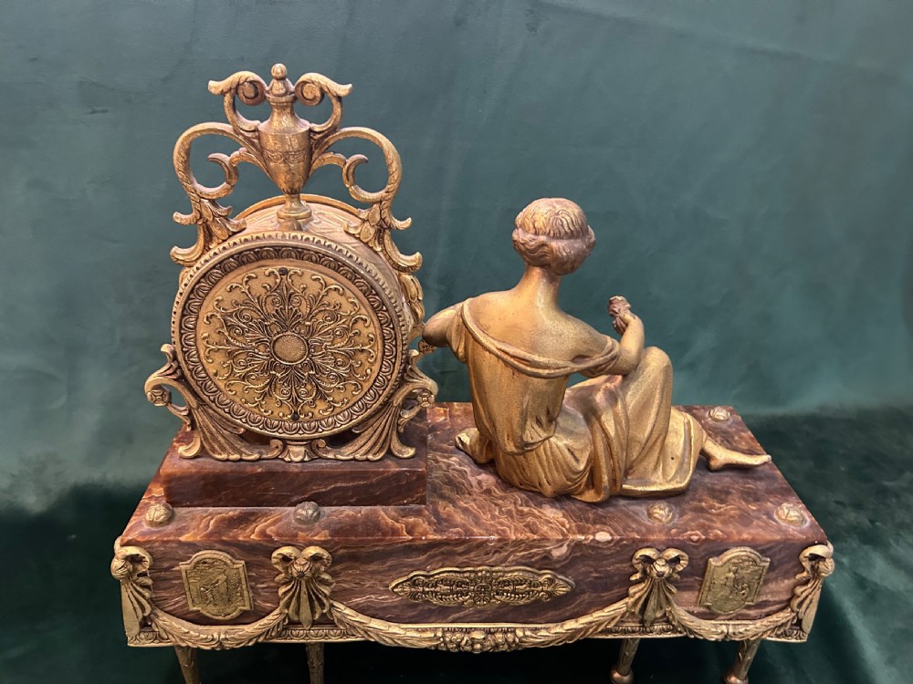 An antique three-piece French ormolu clock garniture featuring a central mantel clock decorated with a classical female figurine and marble base, flanked by two matching five-arm candelabra. View XIV