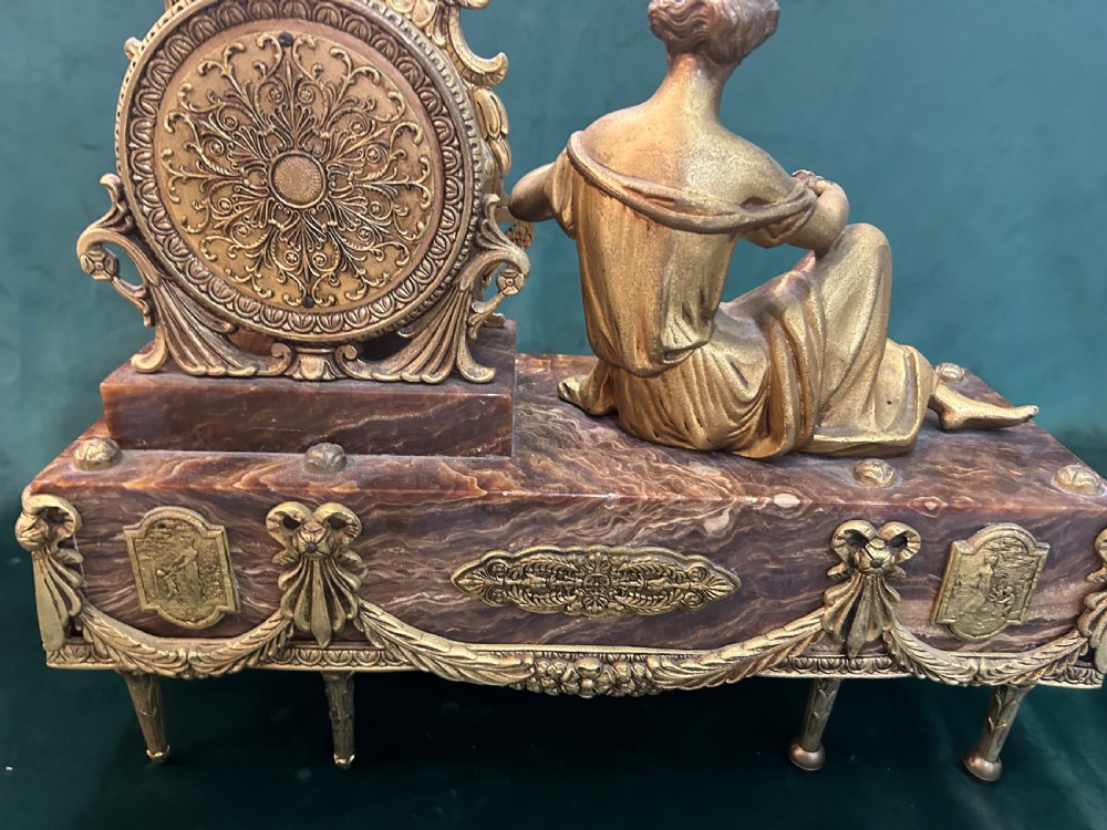 An antique three-piece French ormolu clock garniture featuring a central mantel clock decorated with a classical female figurine and marble base, flanked by two matching five-arm candelabra. View XV