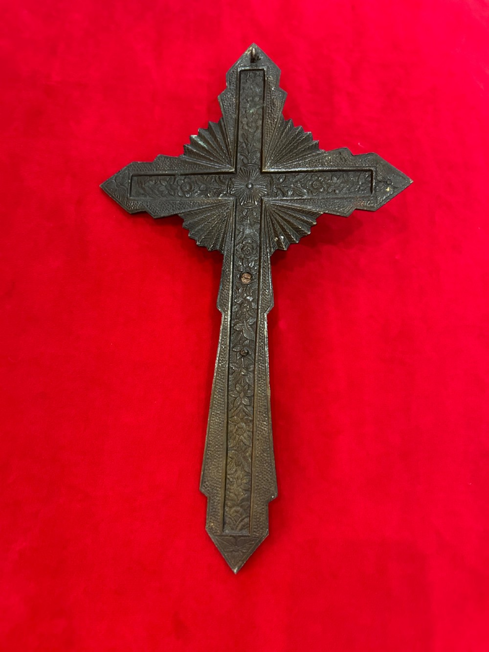An Art Deco brass crucifix featuring a geometric cross structure with a sunburst halo, red enamelled accents, and a relief figure of Christ. View III