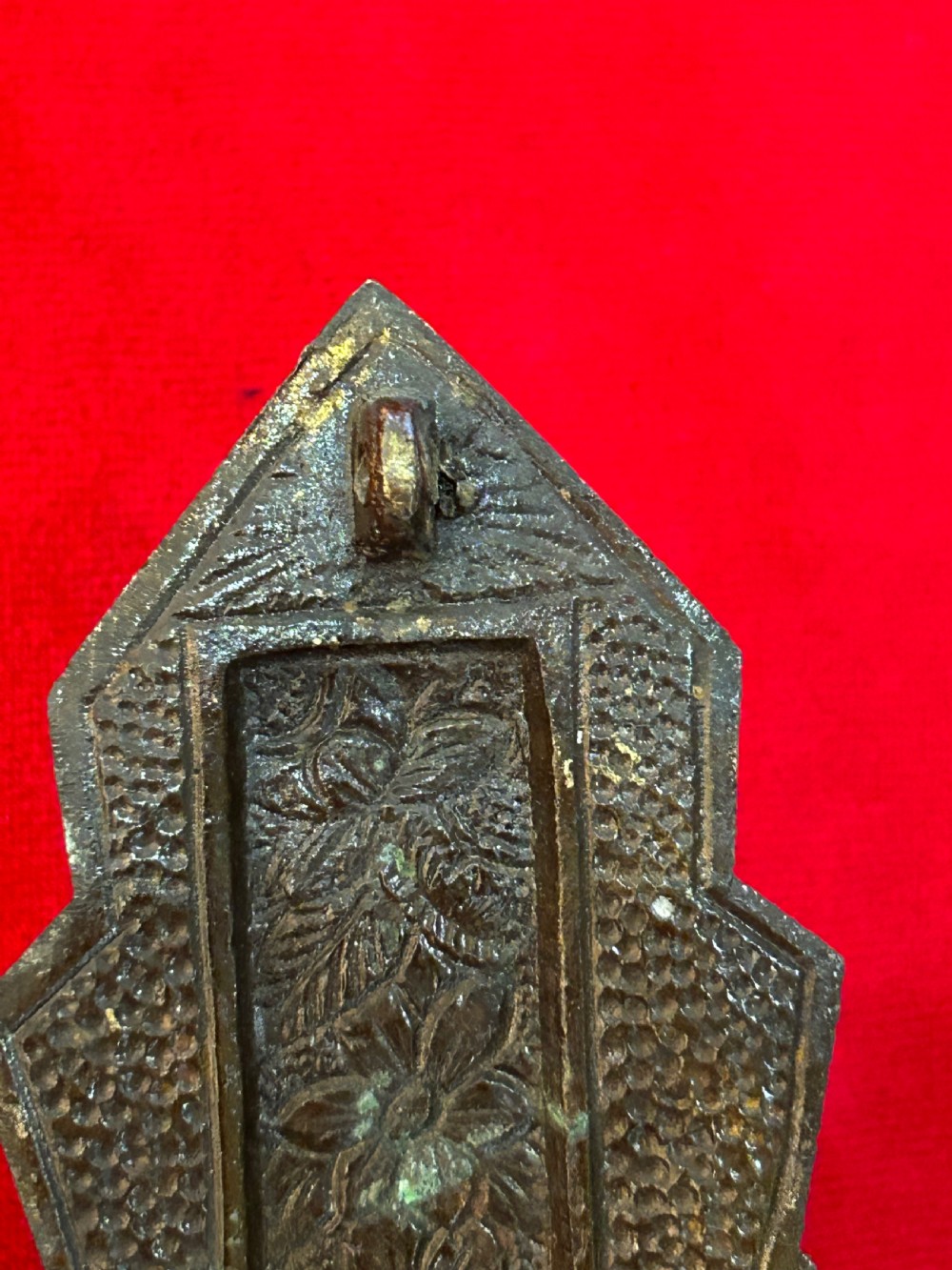 An Art Deco brass crucifix featuring a geometric cross structure with a sunburst halo, red enamelled accents, and a relief figure of Christ. View IV
