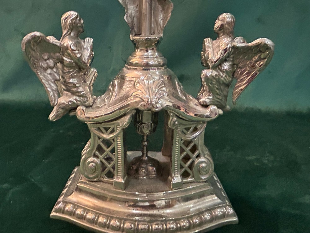 An antique silver metal standing altar cross featuring shell motif terminals, a figure of Christ, and two kneeling angels on a moulded pedestal base. View III