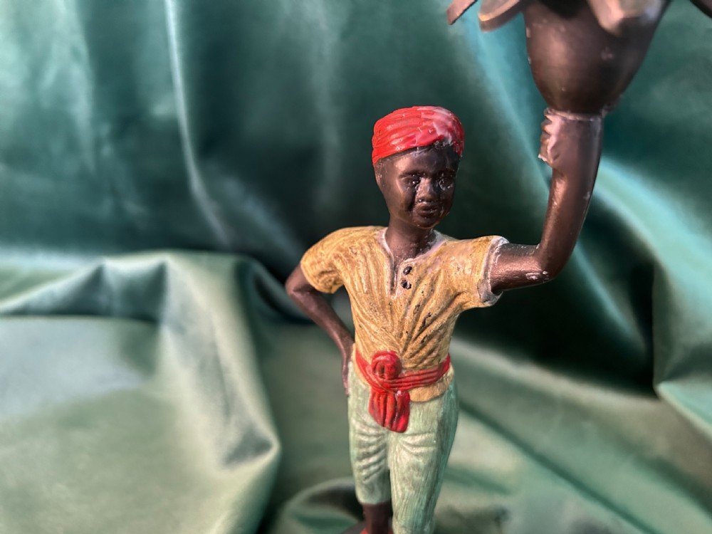 A pair of early 20th century polychrome painted cast metal figural candlesticks with floral sconces. View III