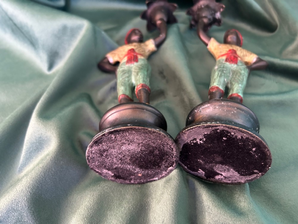 A pair of early 20th century polychrome painted cast metal figural candlesticks with floral sconces. View IV