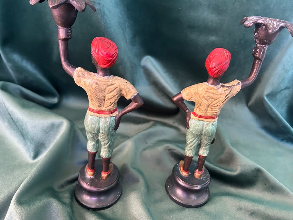 A pair of early 20th century polychrome painted cast metal figural candlesticks with floral sconces. View VI