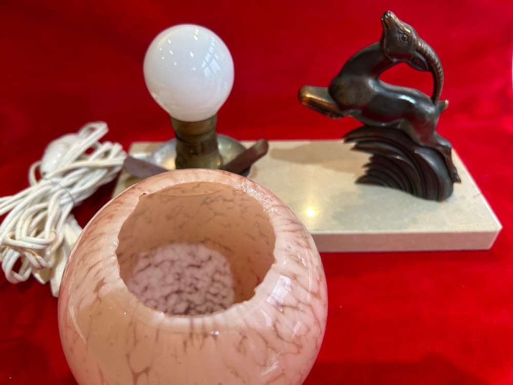 An Art Deco table lamp featuring a rectangular beige marble base, a cast metal leaping gazelle figurine, and a spherical mottled pink glass globe shade. View III