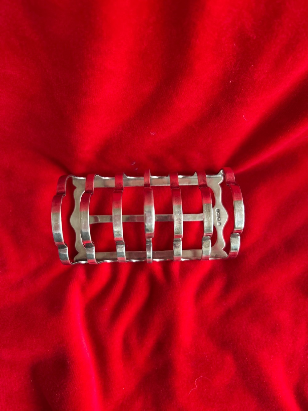 A polished silver toast rack featuring arched wire dividers, a central ring handle, and a six-slice capacity. View II