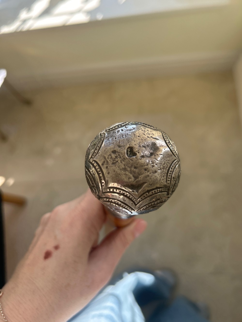 A Victorian walking cane featuring a tapered malacca wood shaft topped with an embossed silver pommel handle. View II