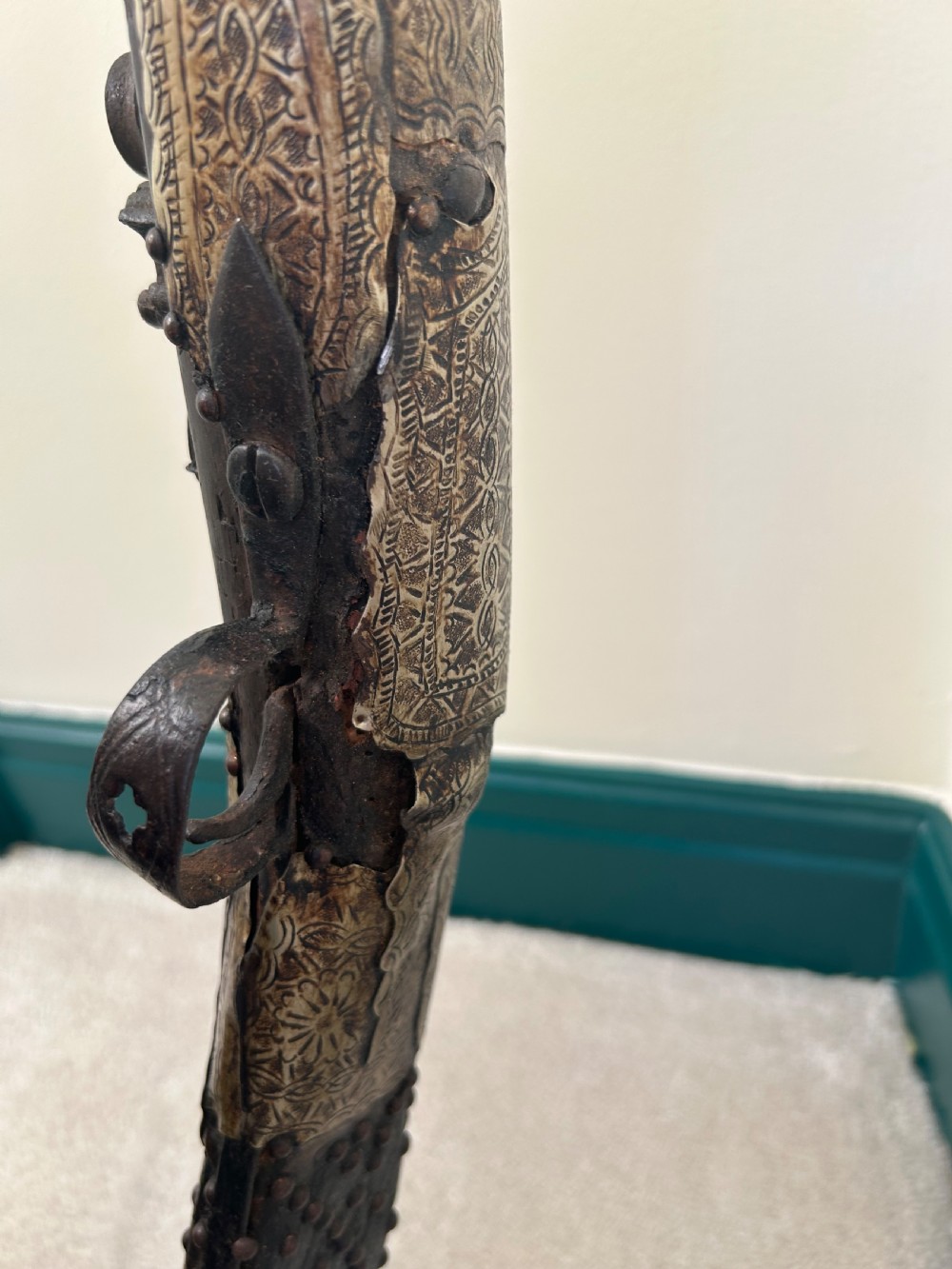 An antique Afghan flintlock Jezail rifle featuring a curved wooden stock adorned with embossed metalwork, a long iron barrel, and a traditional firing mechanism. View III
